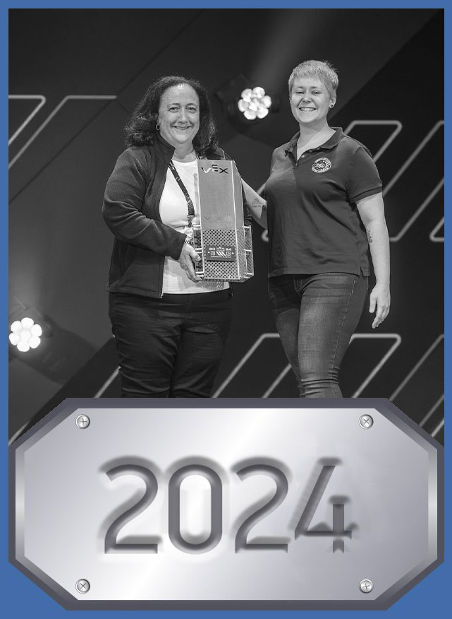 Stem Hall of Fame Profile picture for Margie Eastman, inducted in 2024. Eastman accepts her trophy on stage at the 2024 VEX Robotics World Championship.