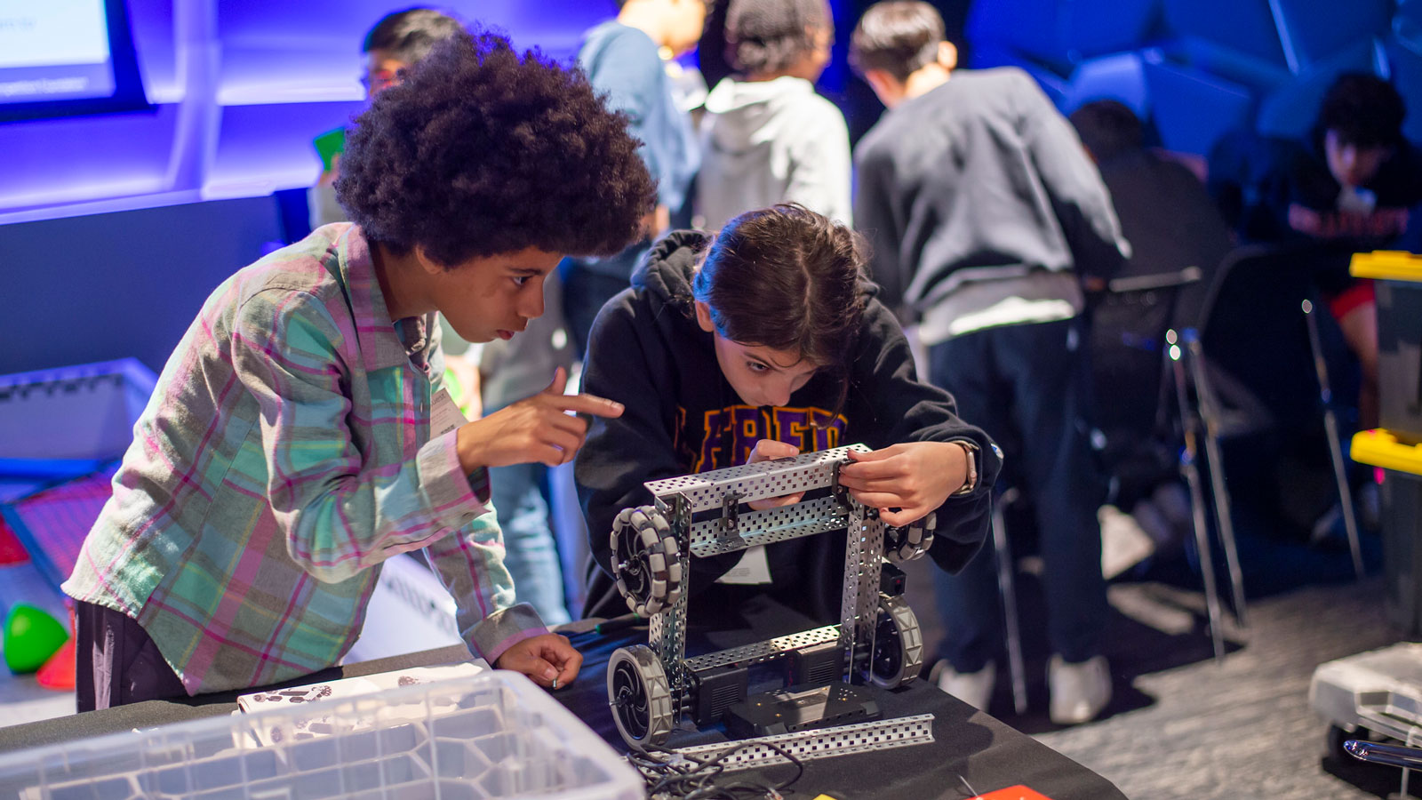 Participants prepare their robots on a field at Prep for Prep