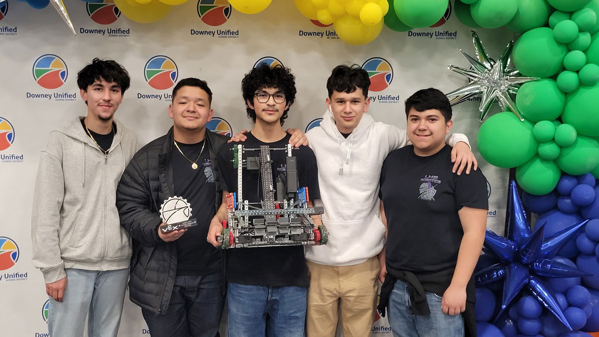 Lynwood High School robotics team poses with an award and their robot.