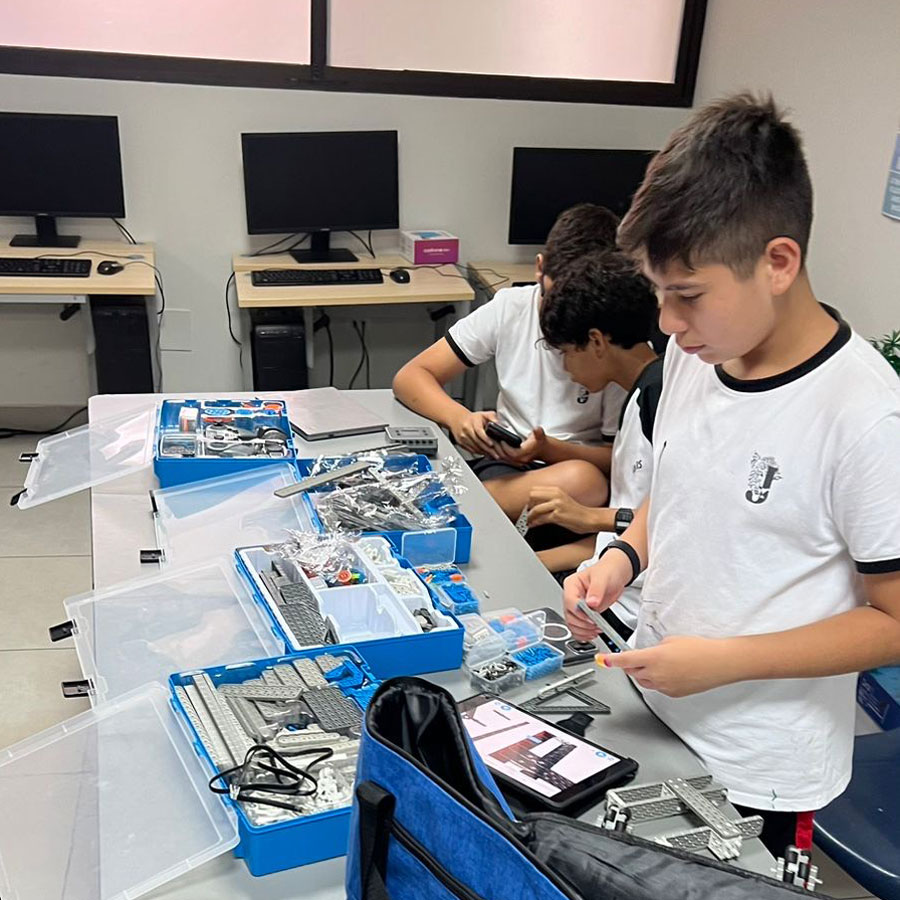 Two robotics students work on their robot on a classroom