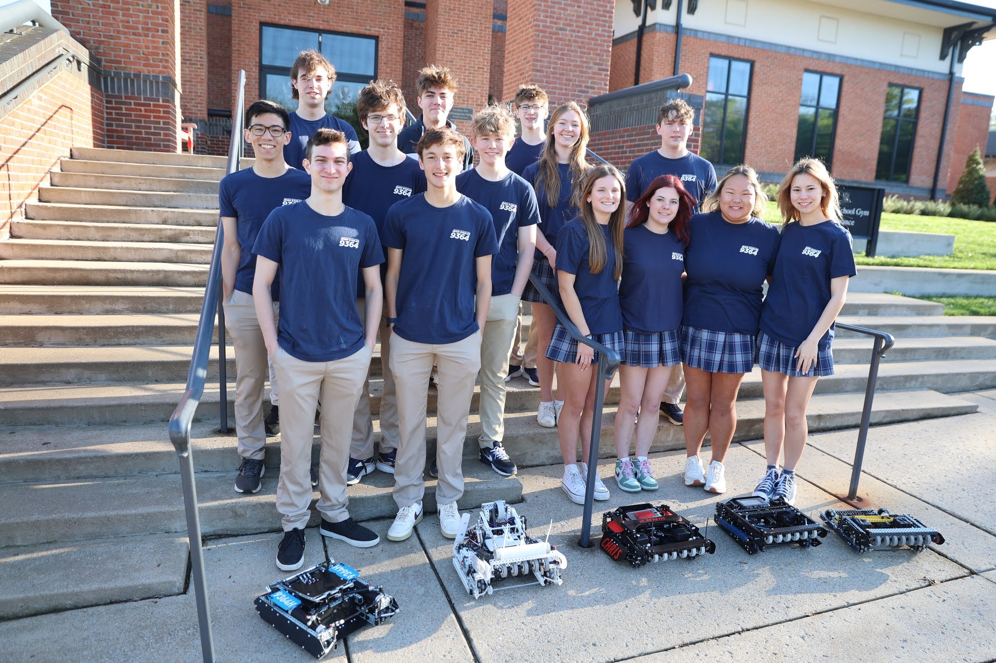 Robotics team poses with their robots